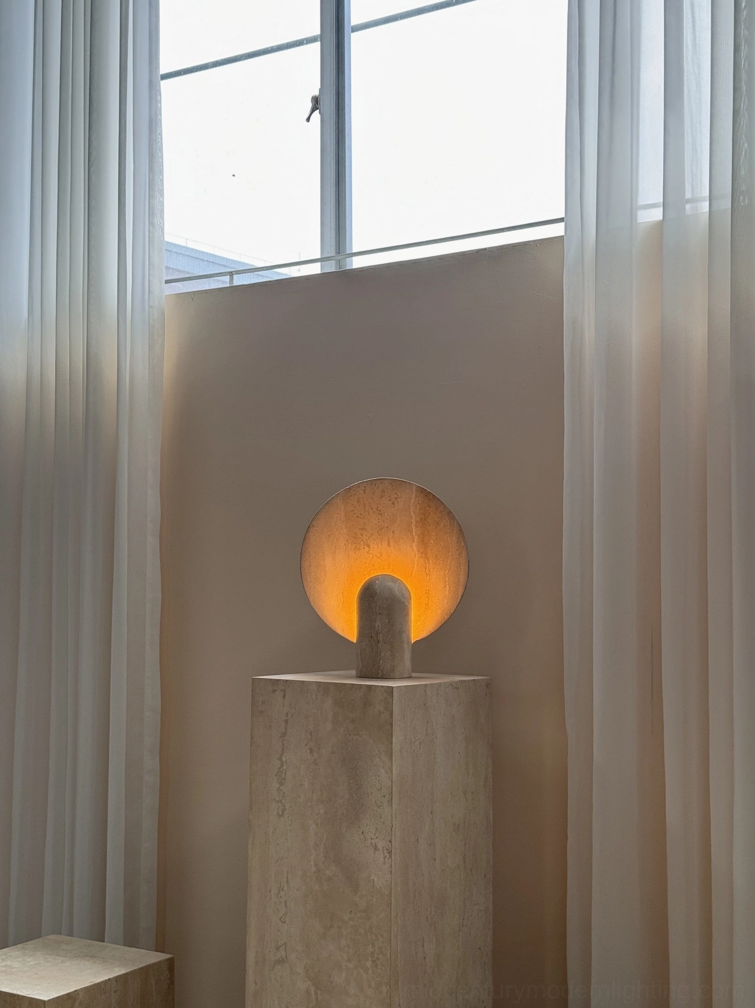 Contemporary marble table lamp three-quarter perspective on minimalist surface emphasizing sculptural form and modern elegance