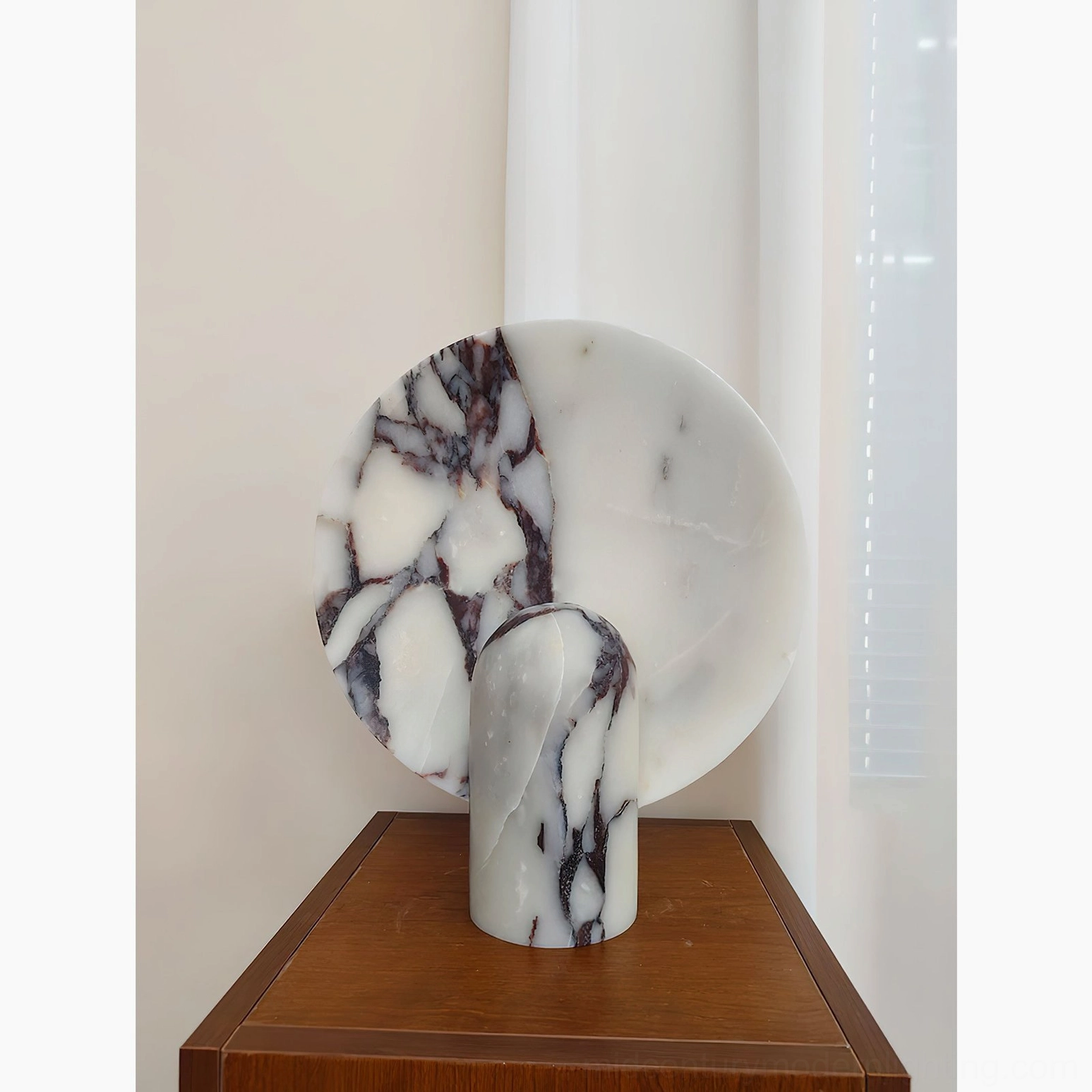 Contemporary marble table lamp in neutral palette positioned as interior design focal point on minimalist display surface