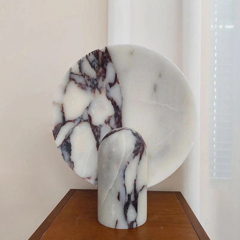 Modern marble table lamp on designer surface showing how sculptural form serves functional purpose in contemporary interior design