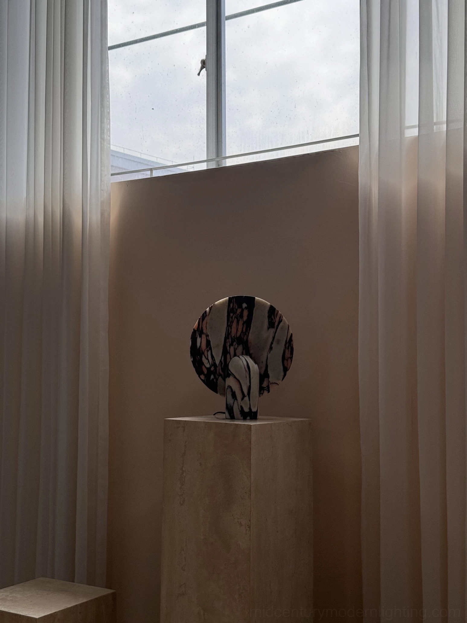 Marble table lamp in transitional interior setting demonstrating versatile styling with modern furniture and warm lighting ambiance