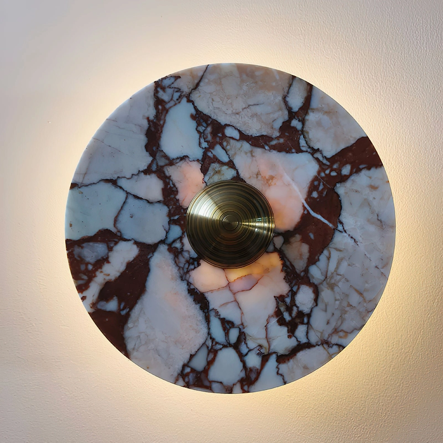 Marble wall lamp with white veining accent on dark stone base showing LED light source through fixture