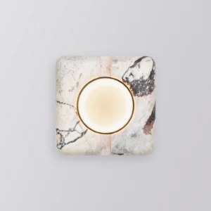 Modern marble wall lamp illuminated with warm LED light glowing from central glass lens