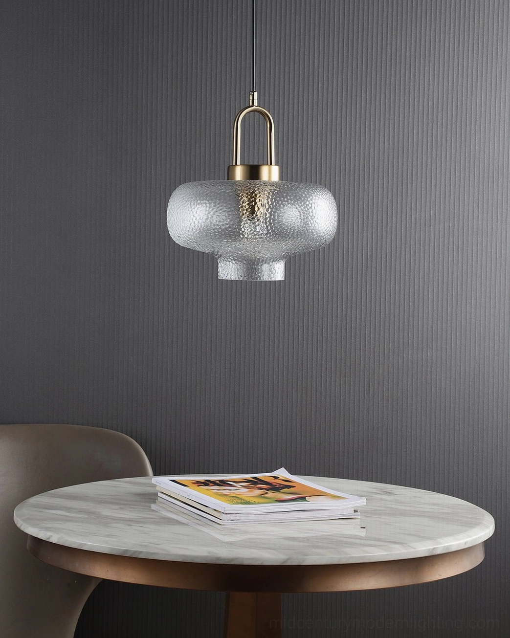 Single Marco textured glass pendant with brass hardware illuminated against neutral background showing light transmission