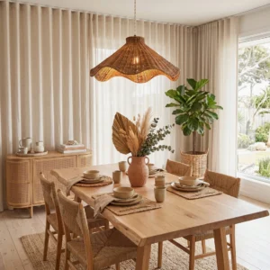 Maren rattan pendant light hanging over farmhouse dining table in warm neutral dining room with natural wood table and minimalist decor