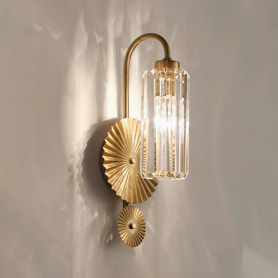 Maria lit brass crystal wall sconce three-quarter frontal angle casting warm shadow on gray wall
