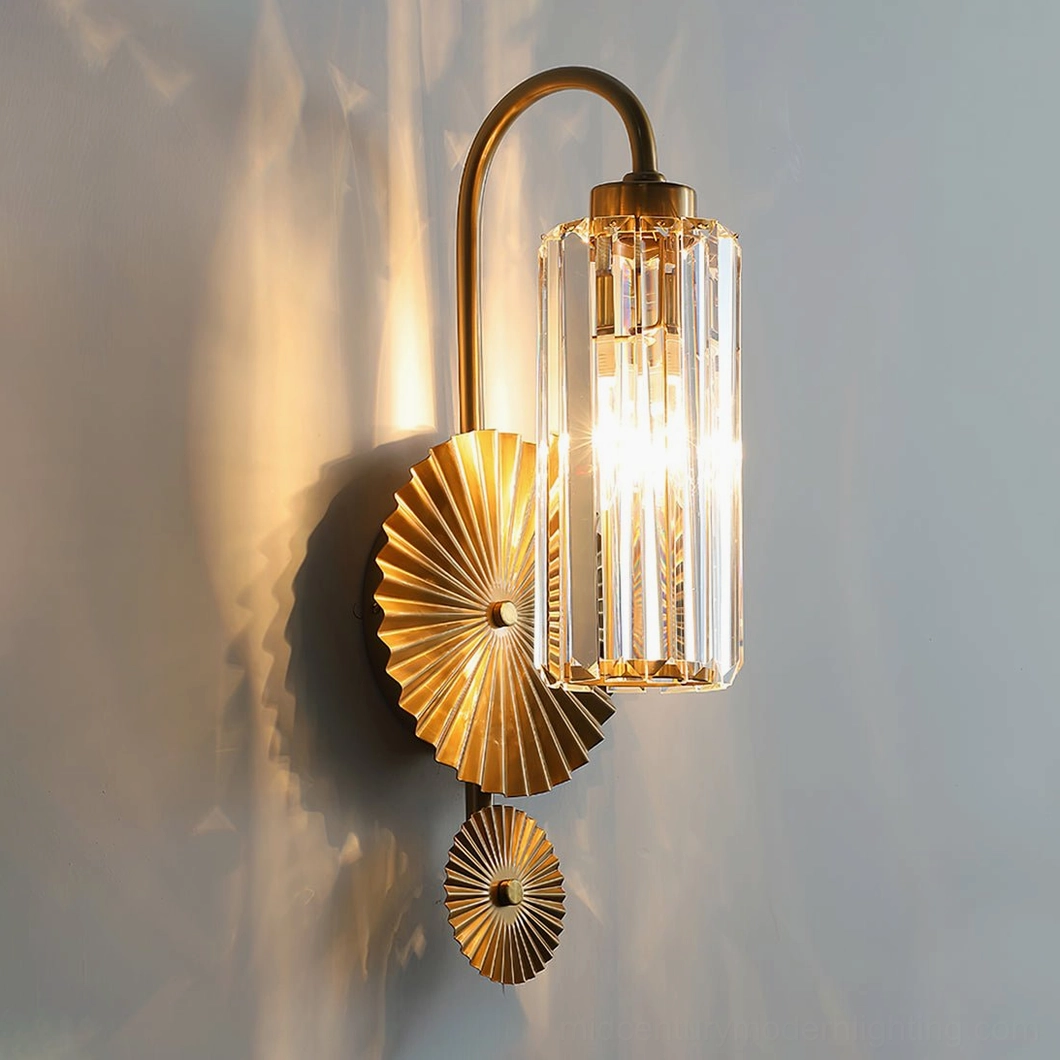 Maria wall sconce illuminated three-quarter angle showing warm glow through pleated glass, mounted on gray wall