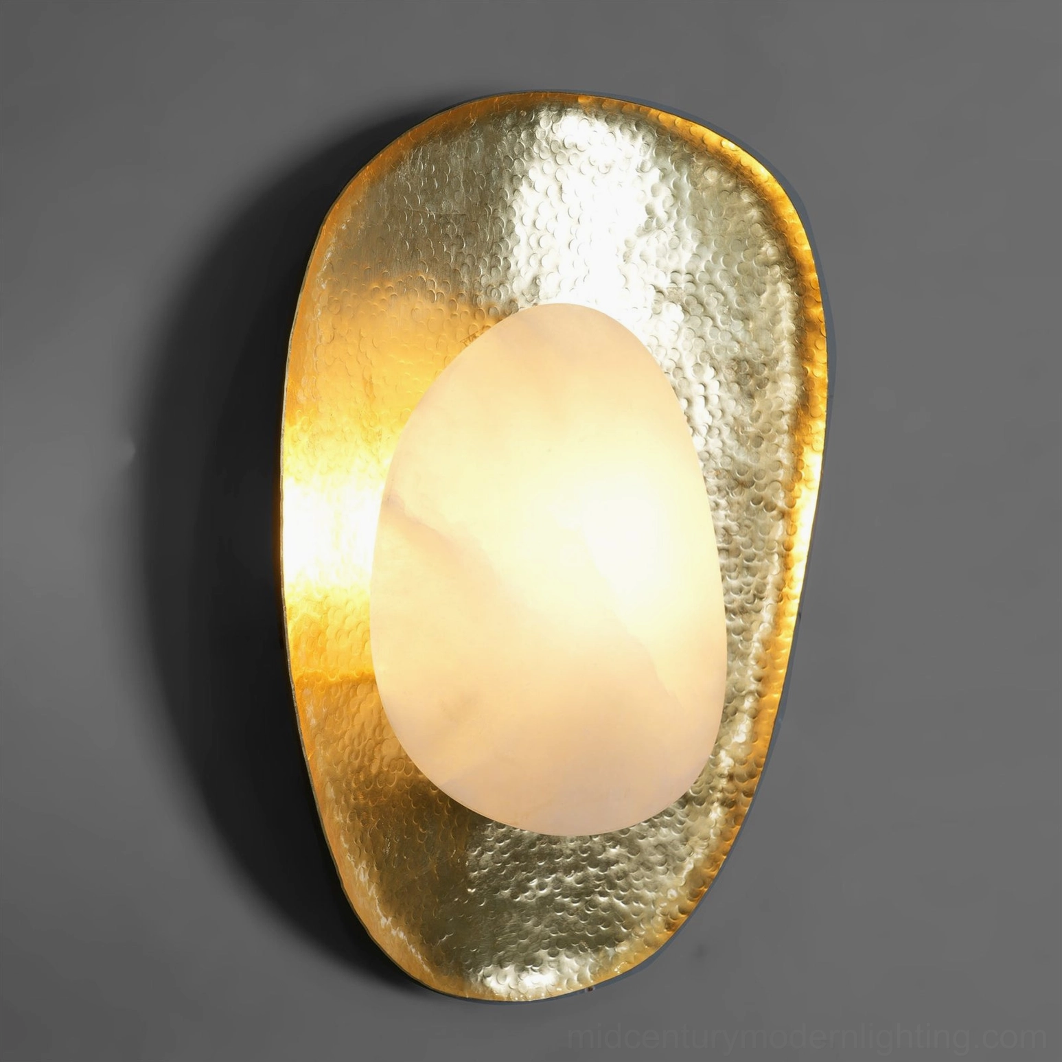 Natural alabaster diffuser with organic veining and brass frame, glowing warm light effect