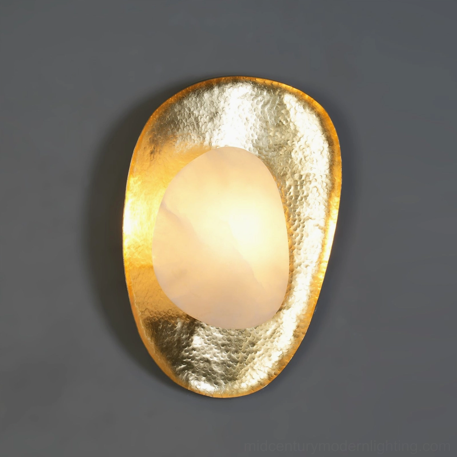 Close-up frontal view of alabaster wall lamp showing polished brass base and warm translucent stone