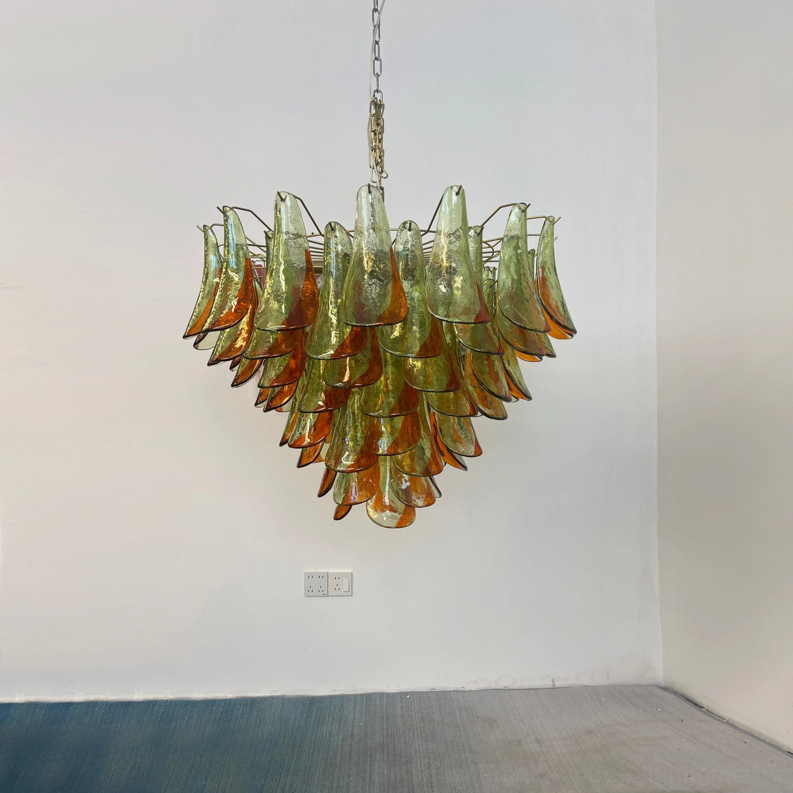 Marielle hand-blown glass petal chandelier installed in minimalist modern room with brass hanging chain