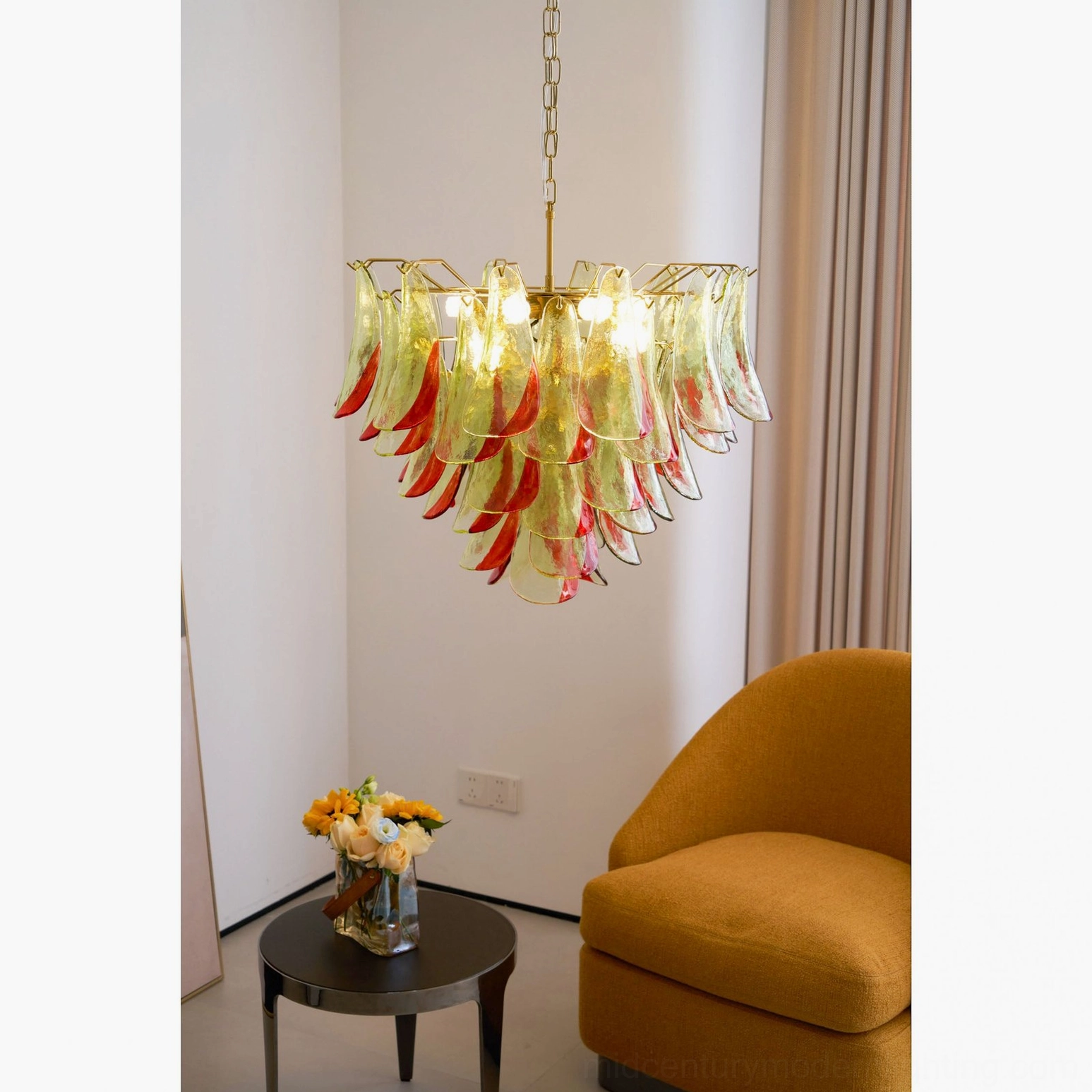 Marielle hand-blown Murano chandelier illuminated in cozy seating area, brass hardware visible
