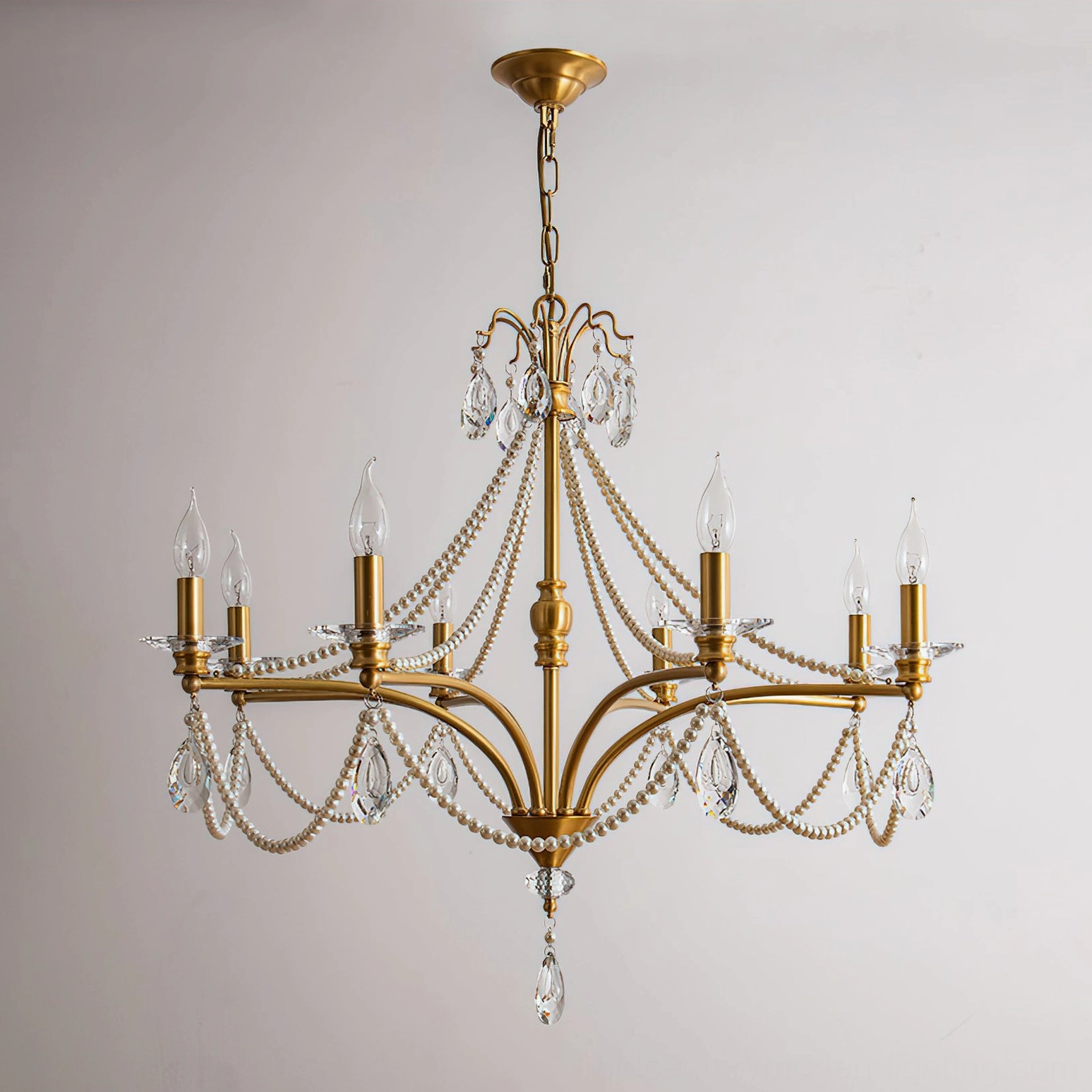 Studio shot of 8-head Mariposa crystal chandelier with brushed brass frame on white background