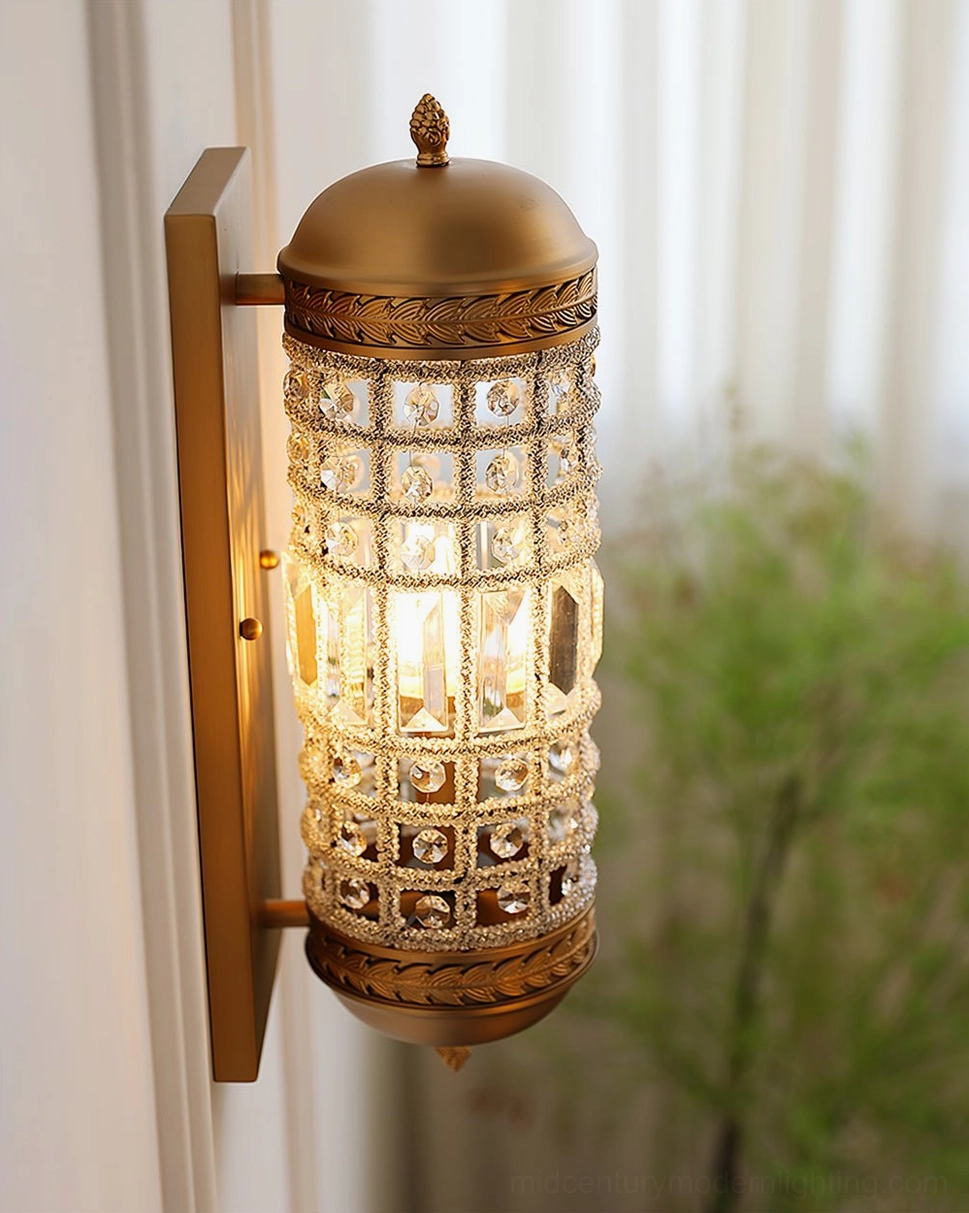 Fully illuminated crystal wall sconce with sheer curtains and greenery in home space
