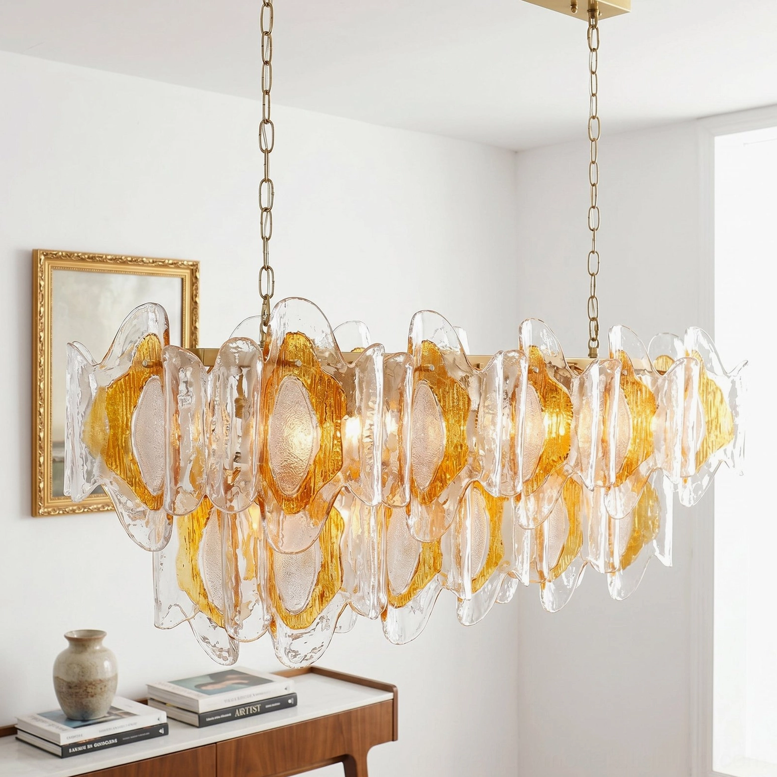 Marrina chandelier front close-up at eye level showing brass gold suspension chain and layered amber-tinted sculpted glass design