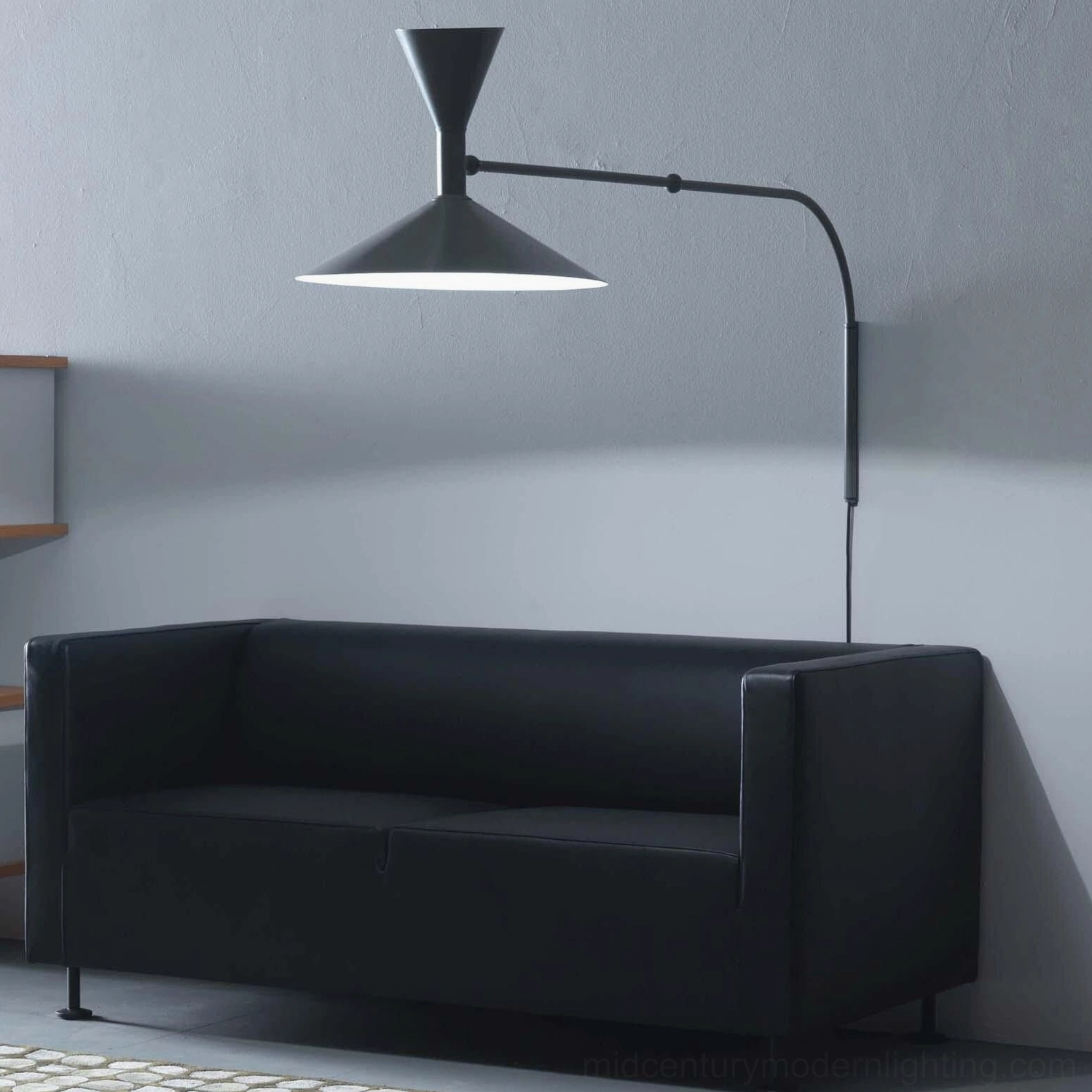 Black Marseille swing arm wall lamp installed in contemporary living room with fabric sofa