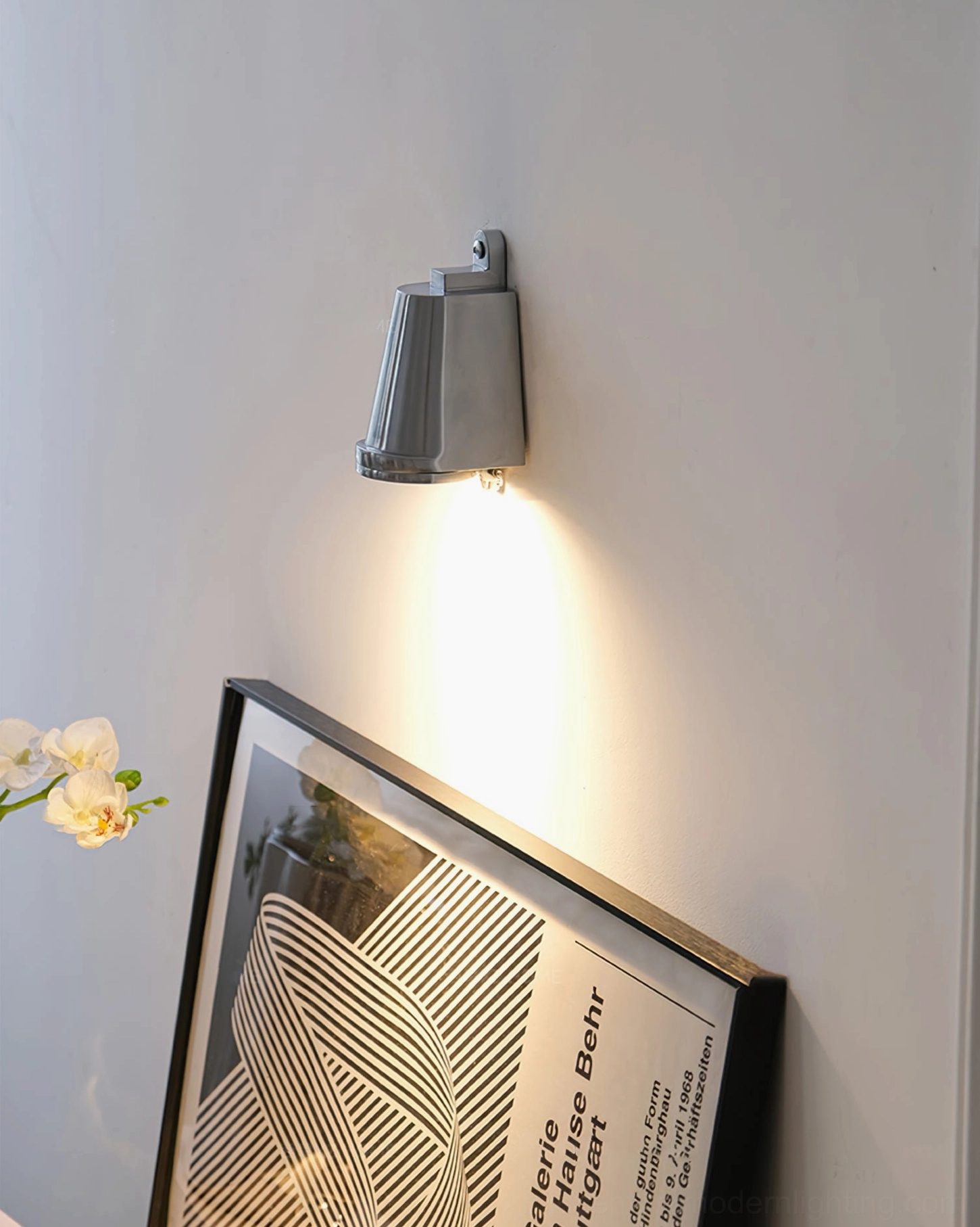 Mast compact wall mounted light with matte silver finish on geometric art wall