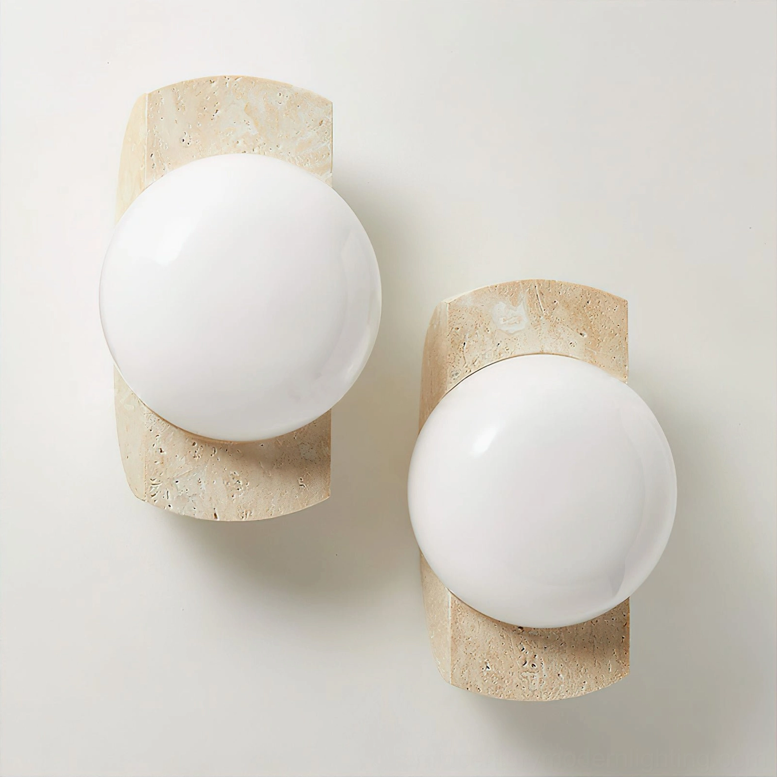 Matching pair of Neptune travertine wall sconces with white glass globes