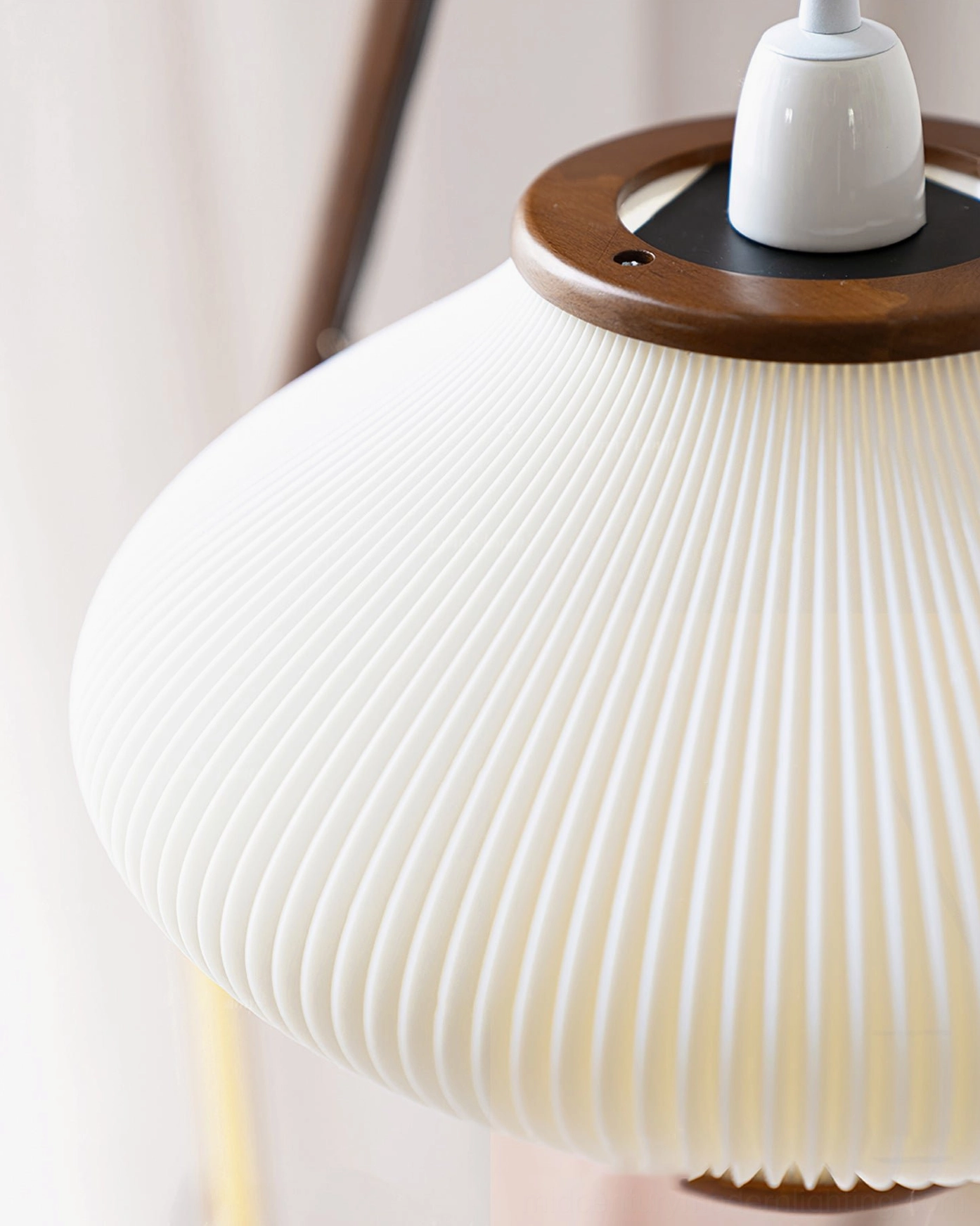 Close-up detail of Matsusu lampshade with ribbed pleated fabric, wood ring trim and ceramic socket