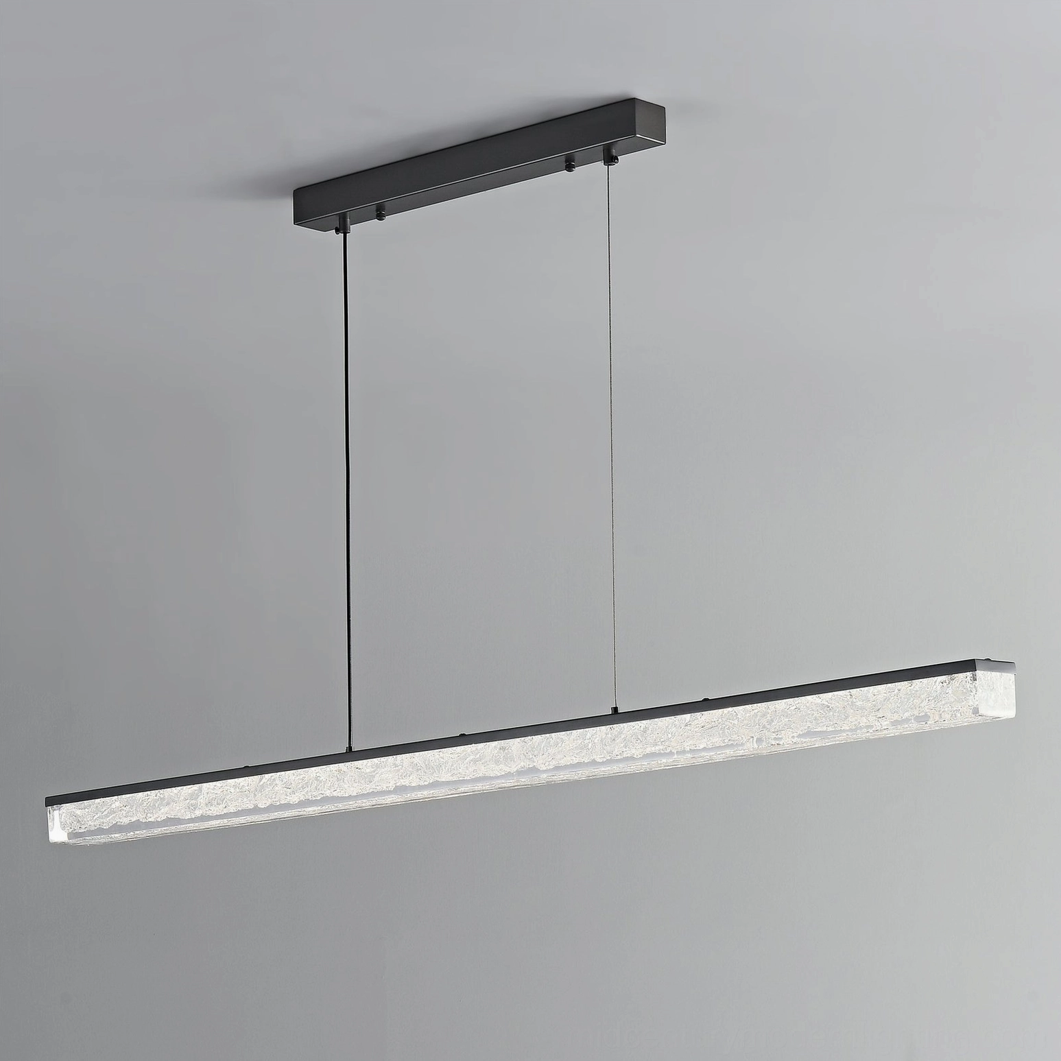 Matte black linear pendant chandelier creating warm ambient light in contemporary home interior