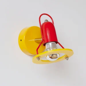 Maurer wall lamp from top angle showing yellow shade ring and red lamp body, Memphis design color block details