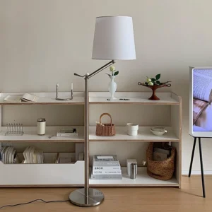 Medea swing arm floor lamp in modern living room with open shelving, silver metal finish