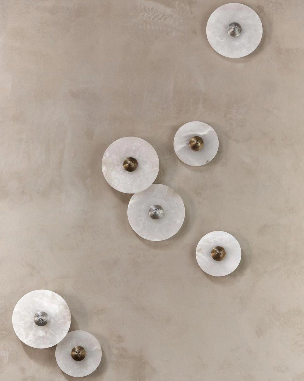 Alabaster wall light close-up detail, fluted stone texture, warm LED glow through translucent stone