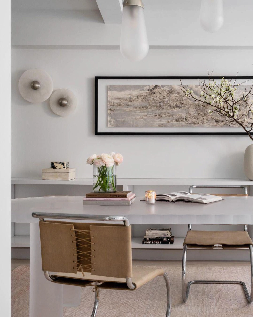 Minimalist home office with pair of round alabaster wall lights, neutral white walls, simple decor