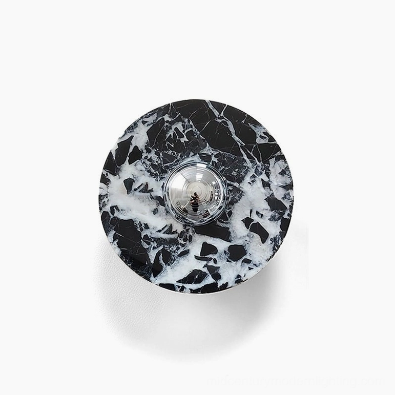 Medium marble wall lamp design with black stone and chrome accent mounted on interior wall