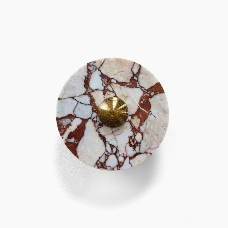 Medium diameter red and white marble geometric wall lamp with brass fixture showing warm terracotta tones