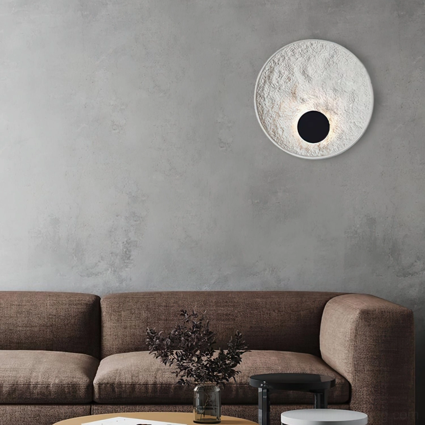 Melesa textured round wall lamp in living room with brown fabric sofa and dried flower table arrangement