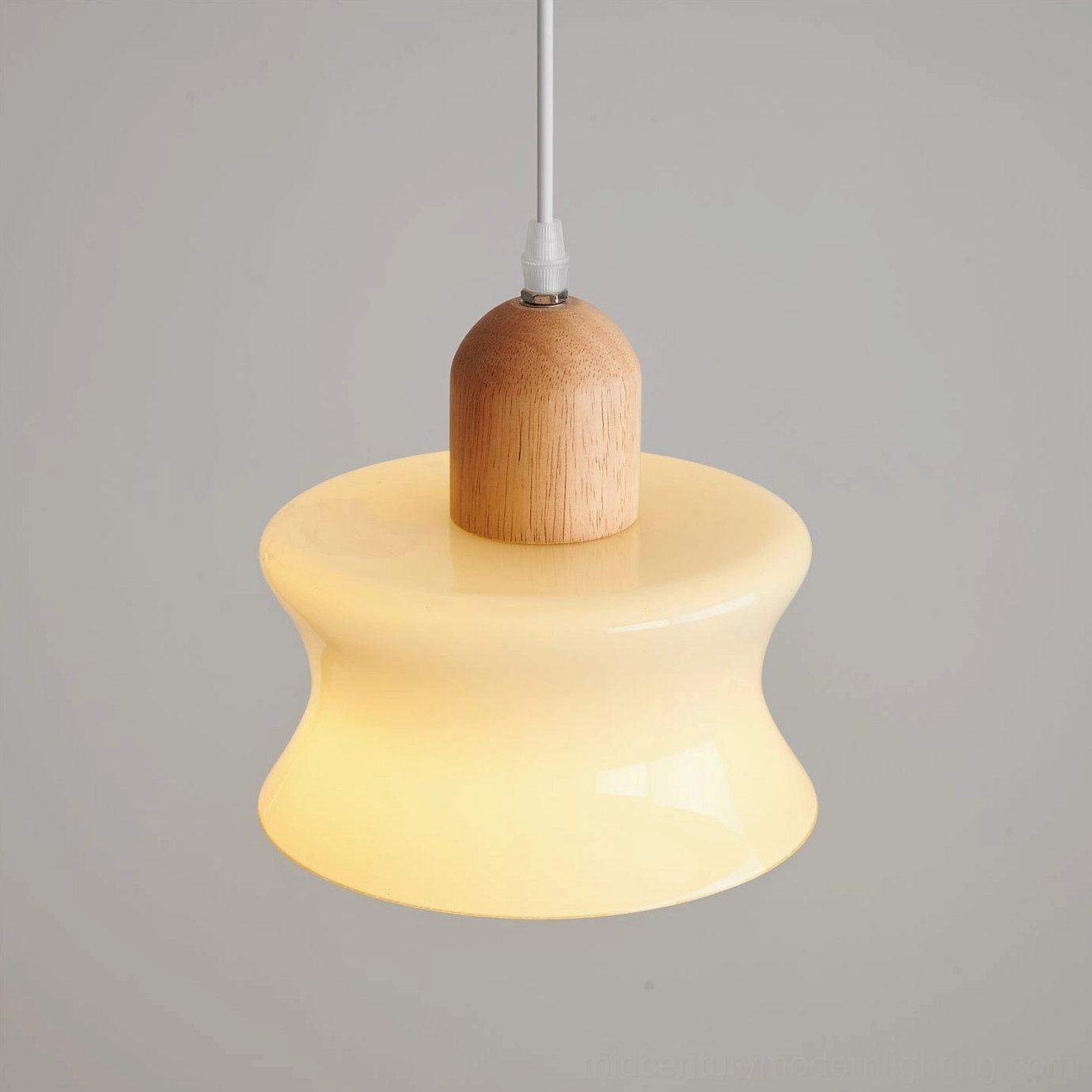 Set of three mellow pendant lights in Nordic dining room above wooden table, creating coordinated warm ambiance