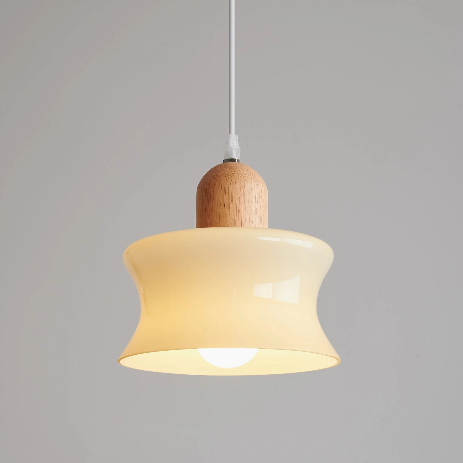 Mellow glass pendant lamp lit from inside showing diffused warm light through frosted shade with curved design