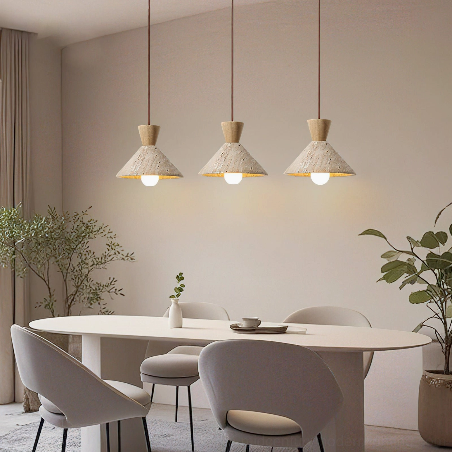 Three Menra pendant lights suspended over round dining table with green plant decorations japandi dining room