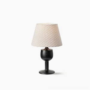 Mermaid table lamp with black stained wood goblet base and beige scallop-embroidered fabric shade, studio front view