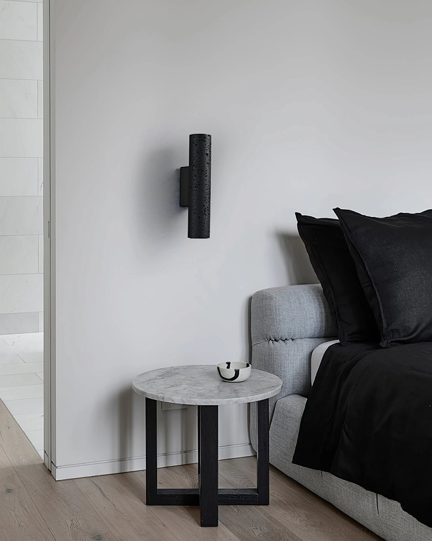 Modern bedroom with Meta cylindrical wall lamp providing accent lighting in contemporary minimalist interior setting