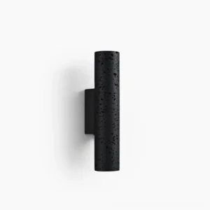 Meta cylindrical wall lamp front view, black matte travertine stone finish with porous texture on white background