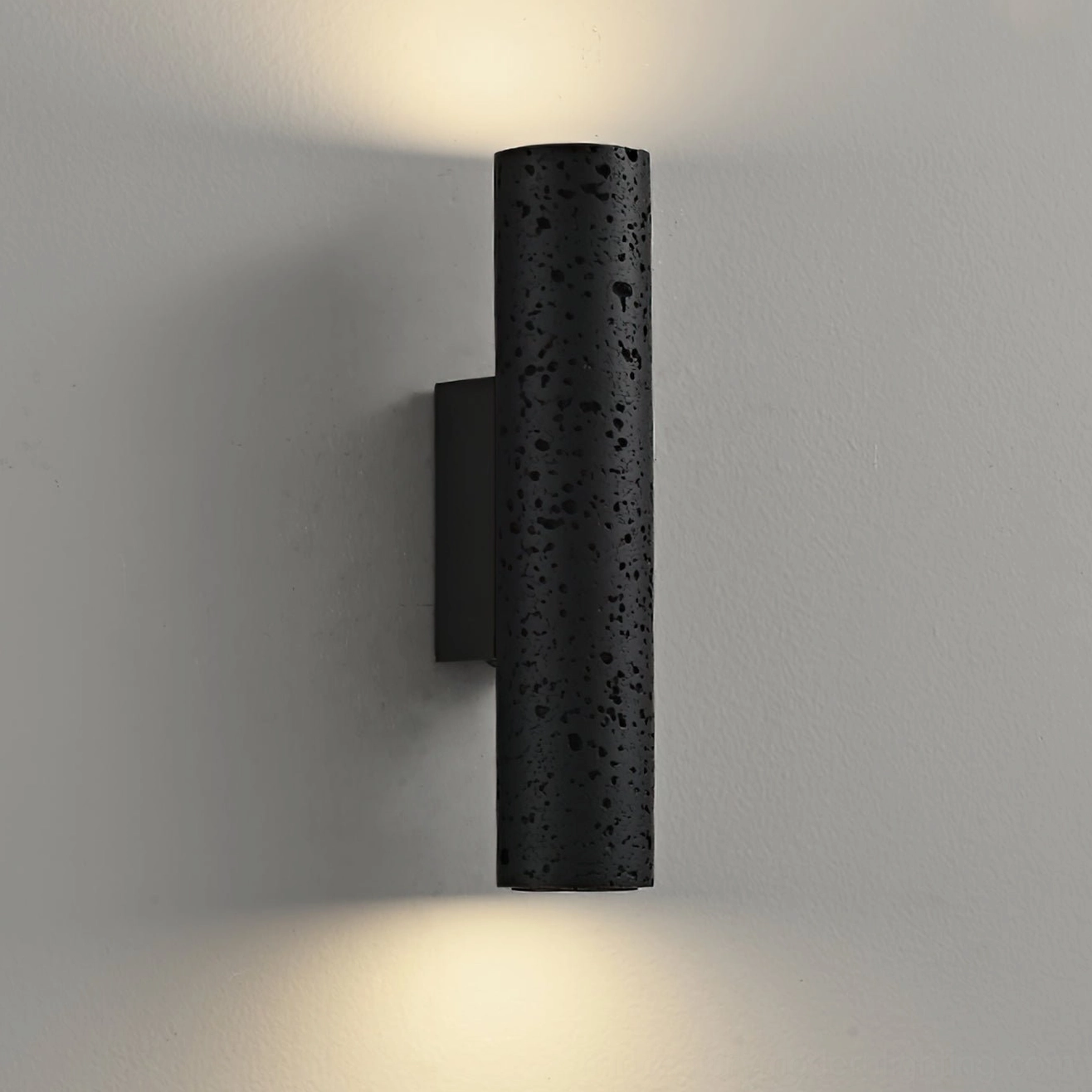 Meta wall lamp installed on white indoor wall, demonstrating warm ambient lighting with upward and downward illumination