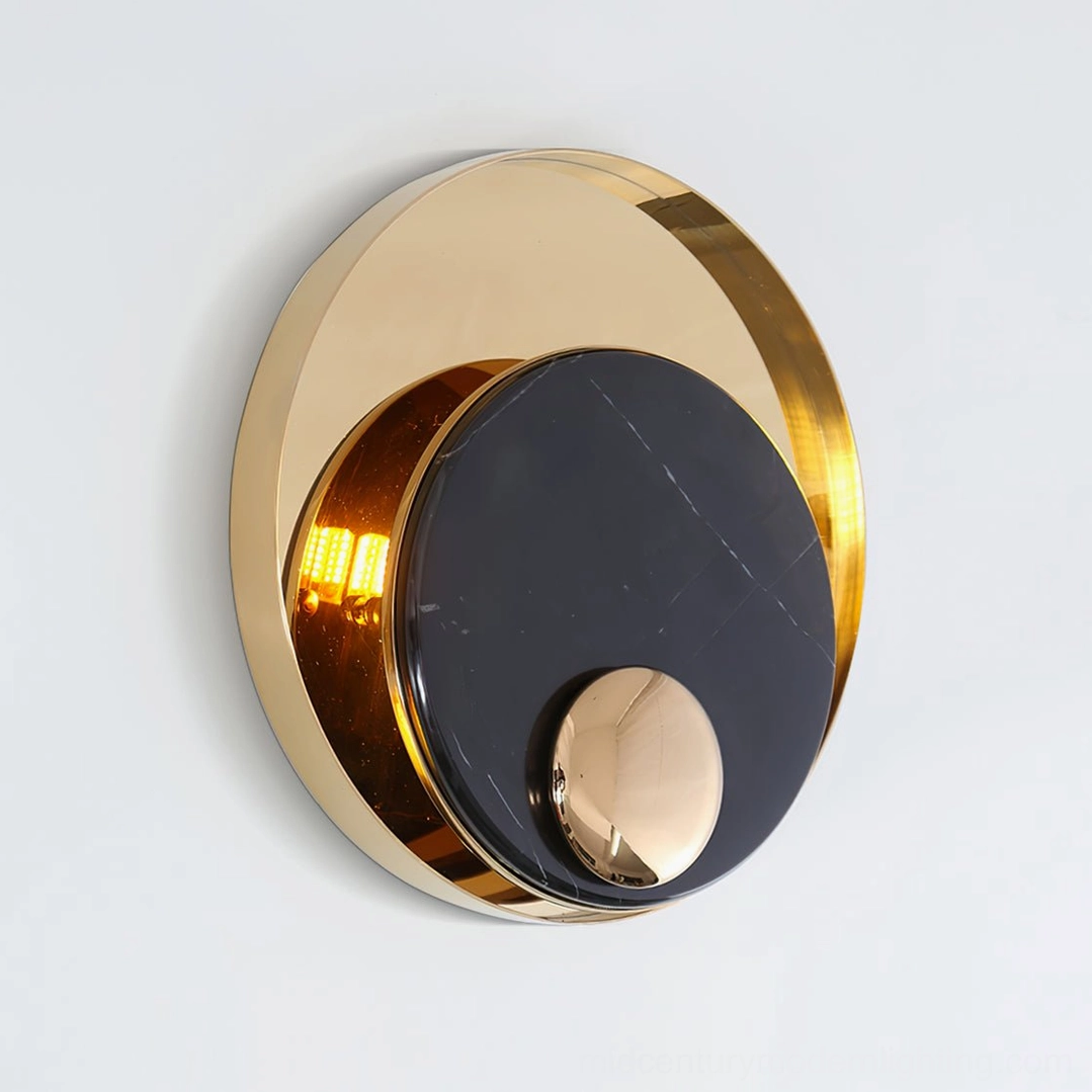 Black marble round wall lamp with polished gold trim finish, close-up studio detail shot showcasing luxury craftsmanship