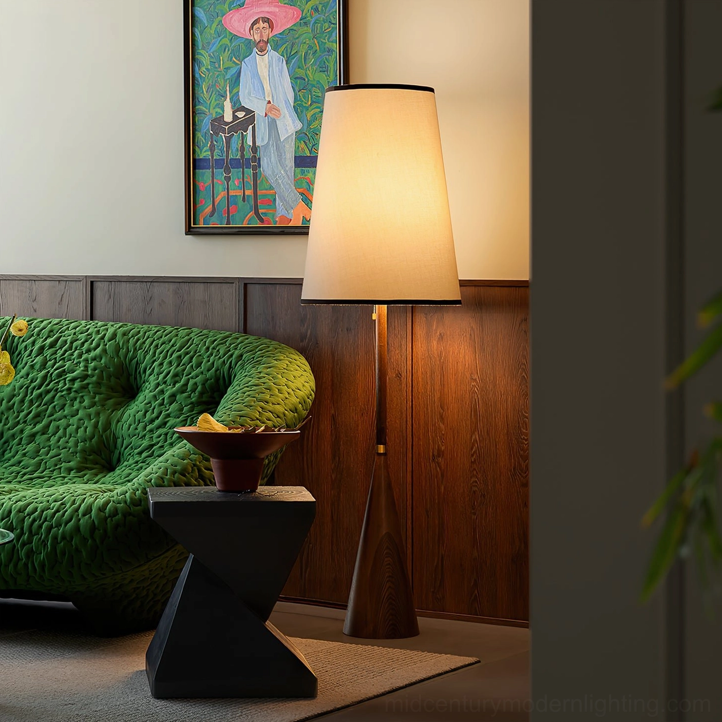 Mezzo standing lamp next to green velvet sofa in retro inspired living room with dark wood paneling