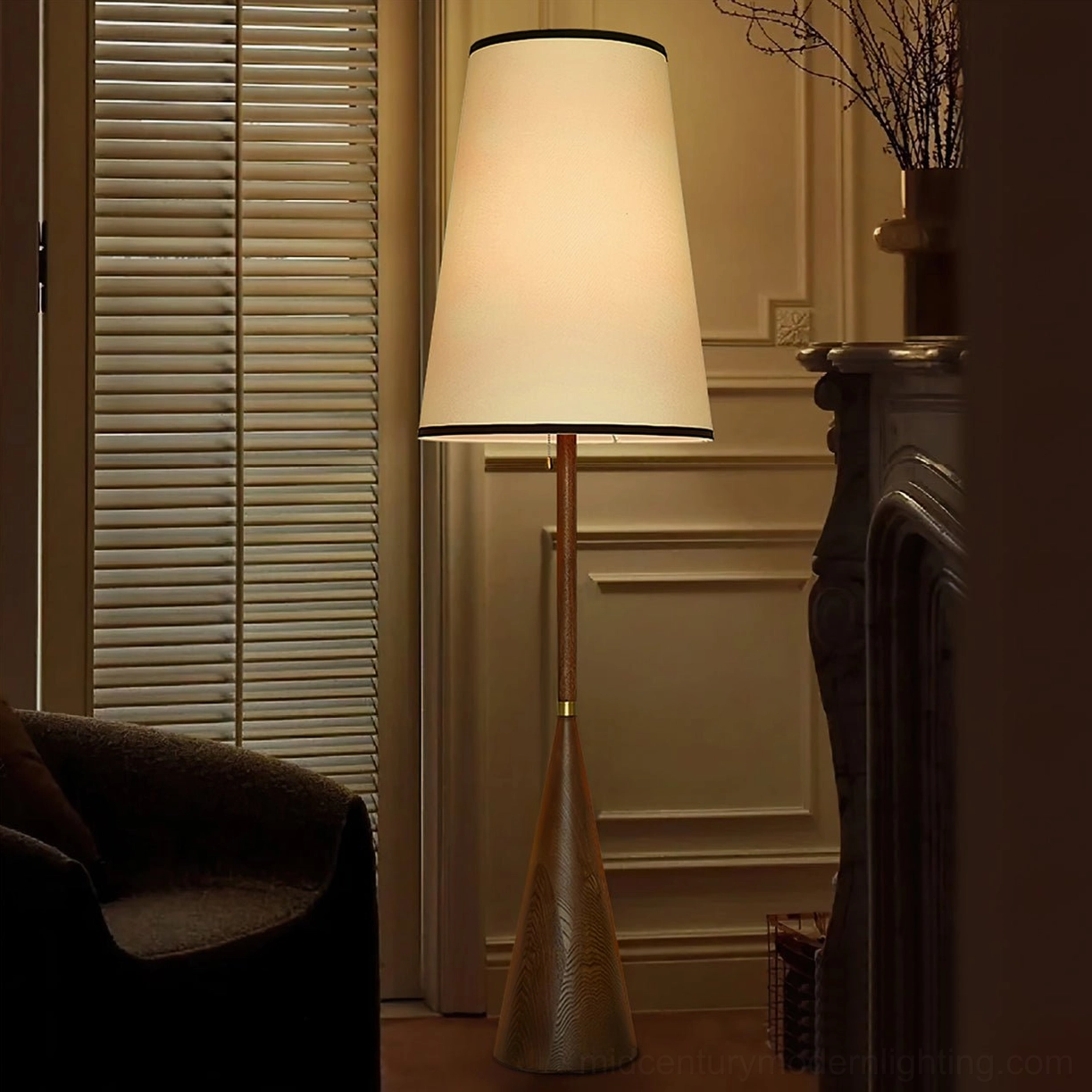 Mezzo mid-century modern floor lamp in vintage paneled room with dark upholstered chair