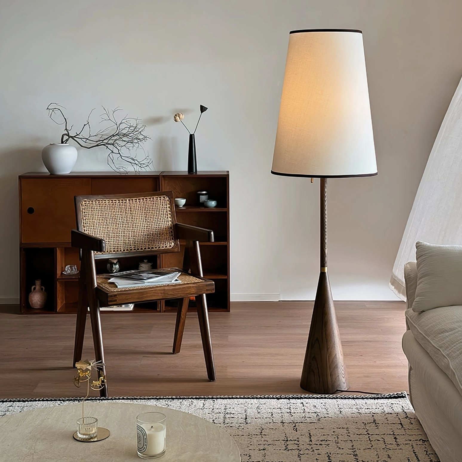 Mezzo mid-century modern floor light in warm vintage interior with wooden cabinet and woven seating
