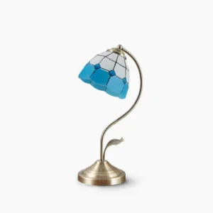 Mica mid-century modern Tiffany style table lamp with floral glass shade and brushed gold base on white background