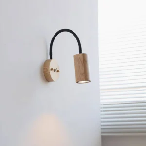 Mid-century modern wood sconce with light oak finish creating warm accent light in bedroom corner
