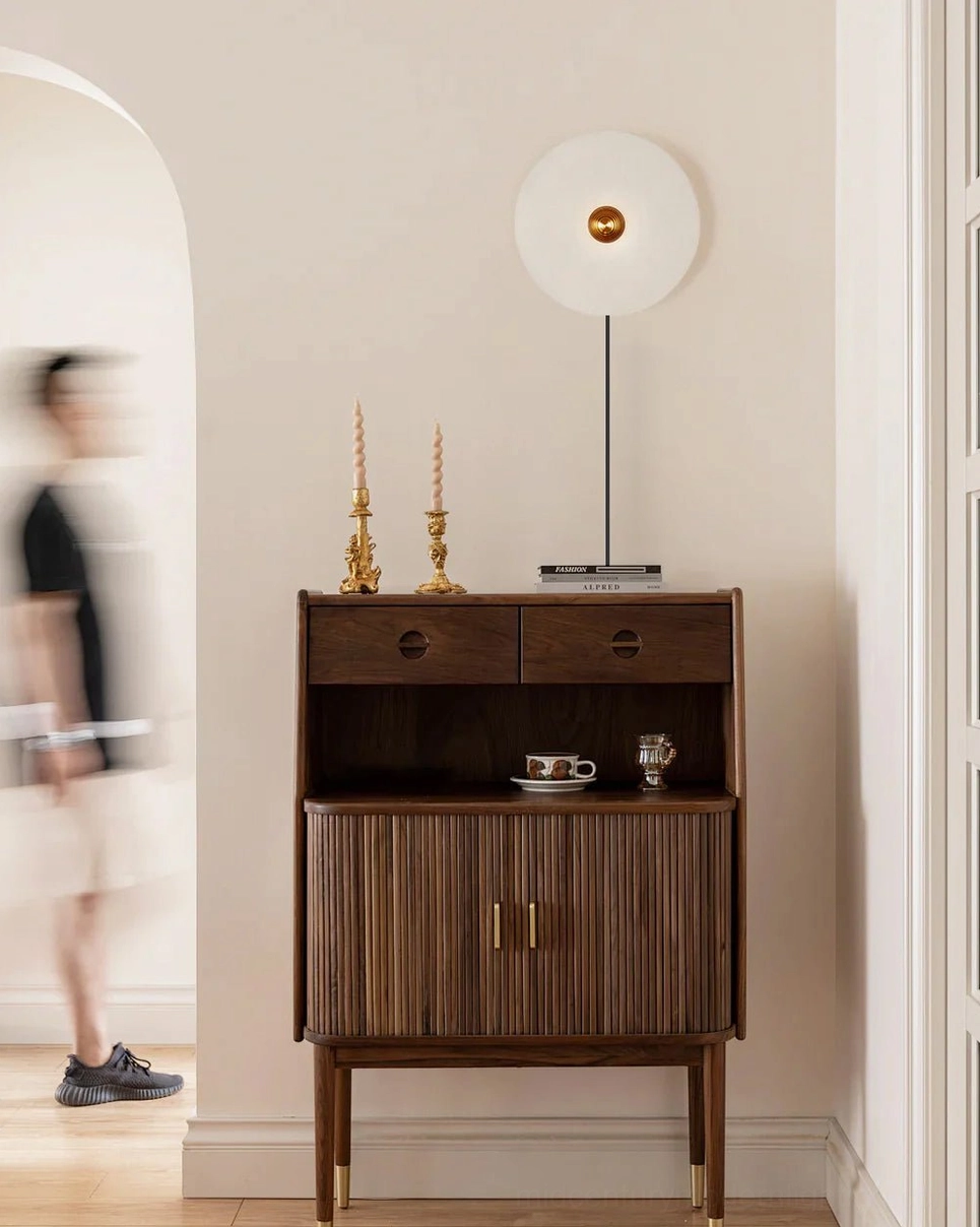Mid-century modern alabaster wall sconce in hallway with mid-century storage furniture