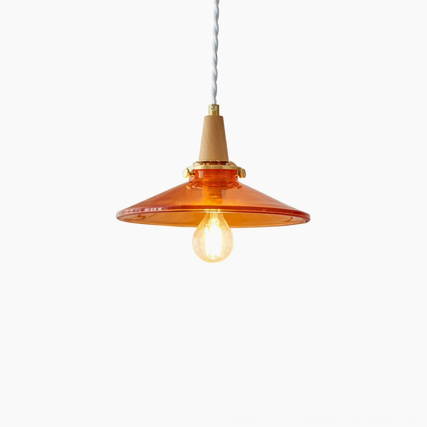 Amber glass pendant lamp in residential setting creating warm, inviting atmospheric lighting for mid-century modern home decor