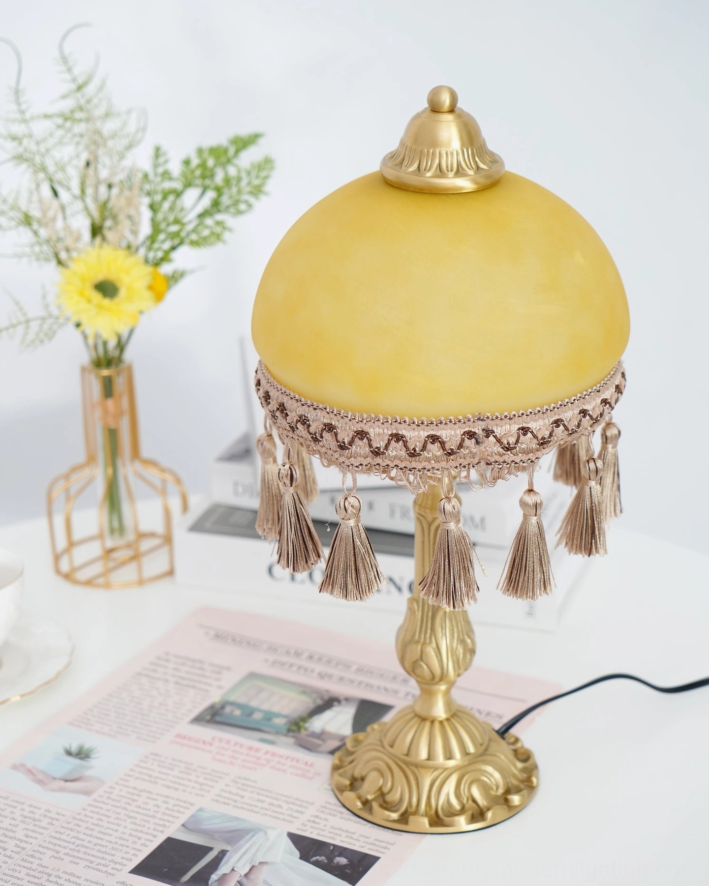 Mid-century modern brass table lamp with intricate tassel detailing and frosted glass