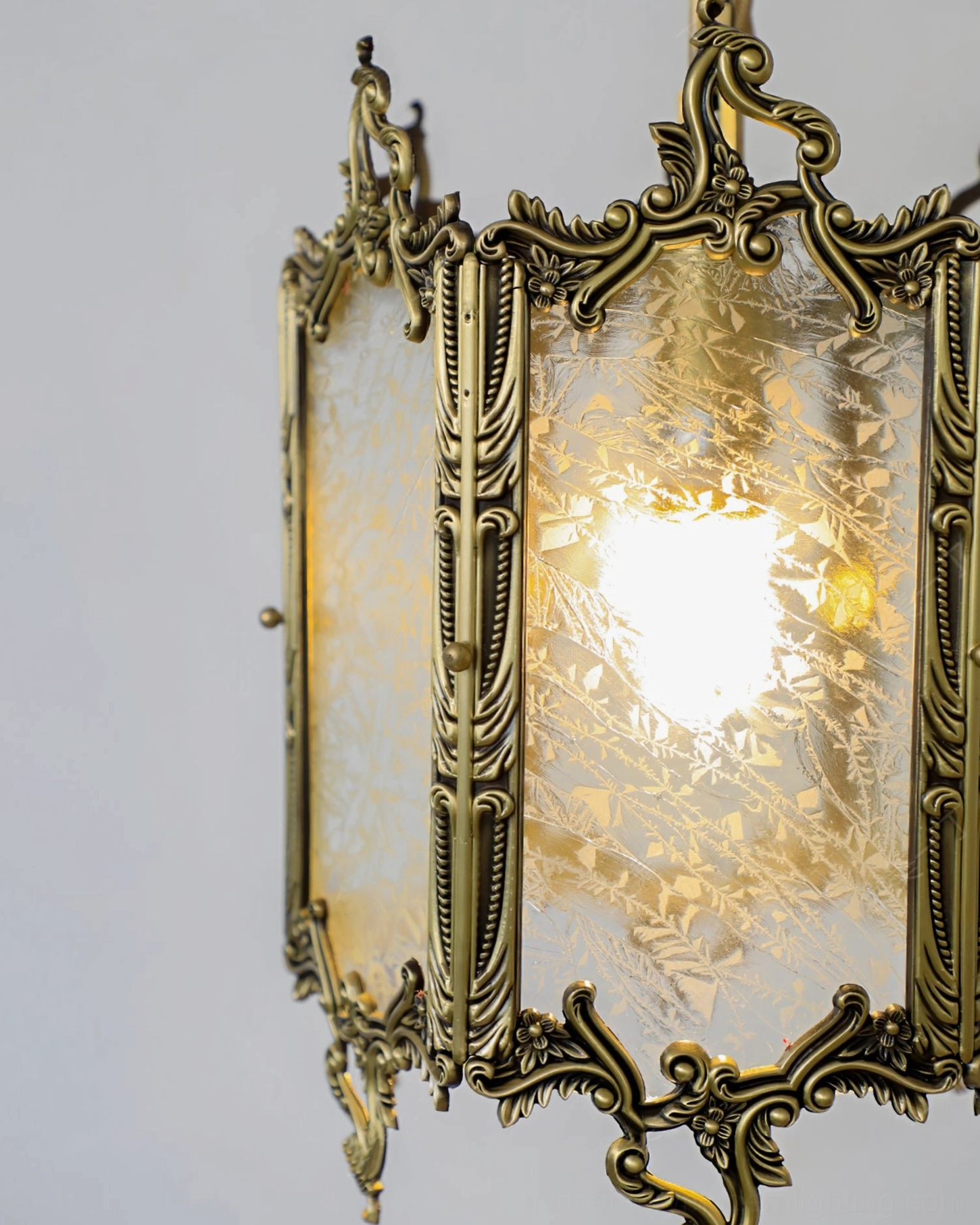 Mid-century modern brass lantern pendant light fixture showcasing detailed brass frame and frosted glass panel diffusion