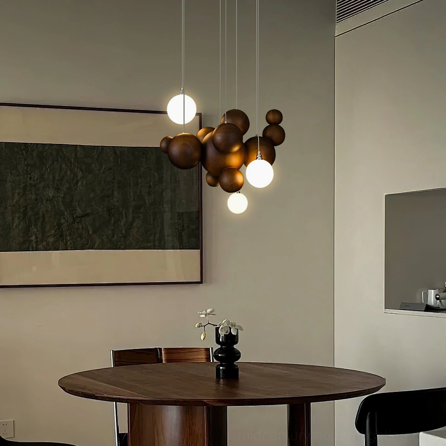 Mid-century modern wood ball chandelier hanging above dining setting with illuminated frosted glass and natural wood elements
