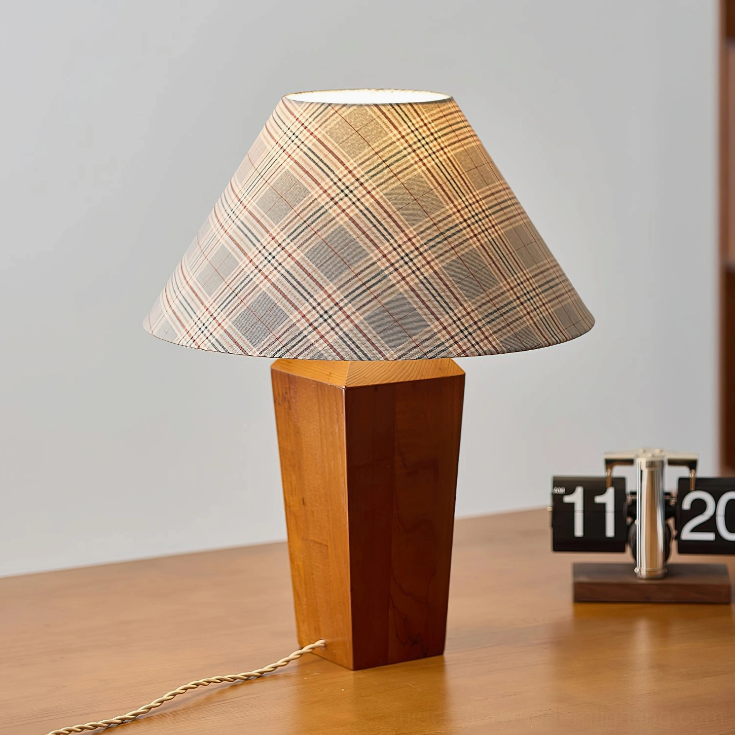 Cabin table lamp on home office wooden desk, three-quarter angle showing brown wood base with checkered lampshade