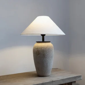 Mid-century modern ceramic lamp positioned on wooden side table in warm interior setting