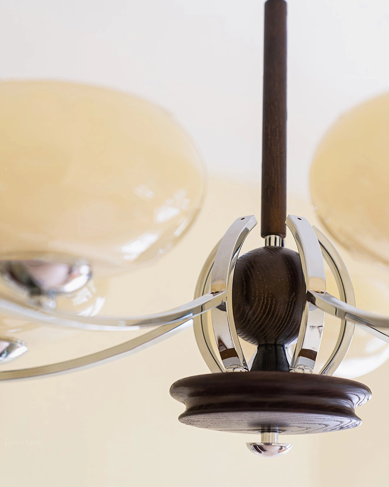 Side close-up angle of chandelier arm section featuring dark wood base, curved chrome arms, and partial cream-toned glass shades